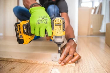Handyman assembling flat-pack furniture with an impact driver