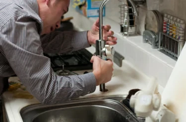 Handyman repairing a kitchen tap