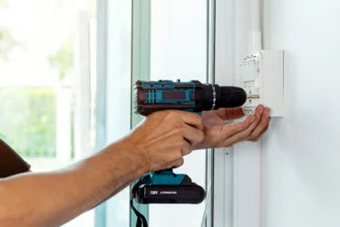 Handyman drilling a fixing into a wall