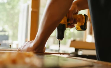 Handyman drilling into a wooden frame